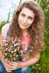 Beautiful woman with bouquet of pink flowers smiling, summer or congratulations concept