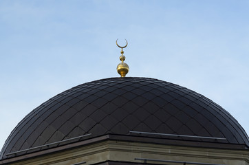 Fototapeta na wymiar View of dome of mosque with a signs of crescent and star. 