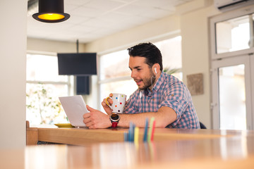 Young male freelancer working from caffe on laptop