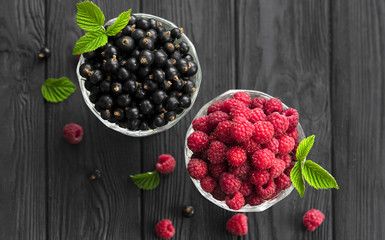 raspberries and currants on a wooden background