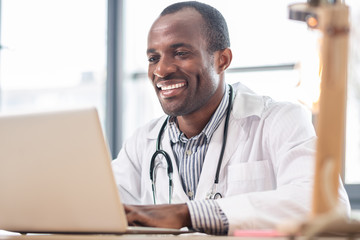 Joyful international male person working with pleasure