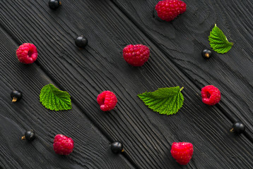 raspberries and currants on a wooden background
