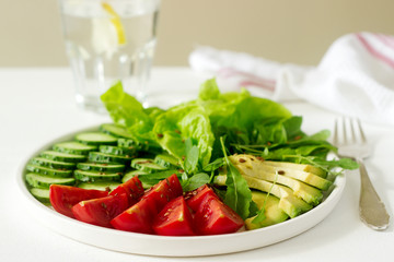 Vegetable salad with avocado and flax seeds on a light background, vegan food.