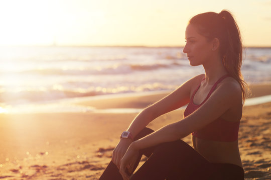 Woman running alone at beautiful dusk on the beach