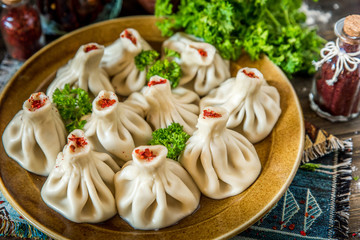 Georgian dumplings Khinkali with meat and red papper, on brown plate