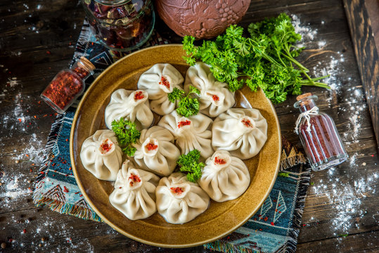 Georgian dumplings Khinkali with meat and red papper, on brown plate