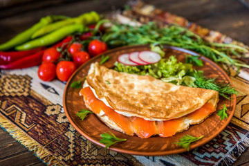 scramble with salmon fish, eggs, on a wood table