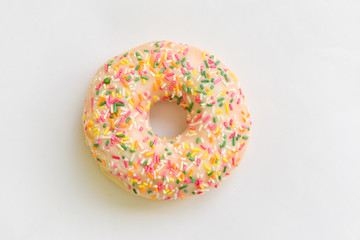Donut with colorful sprinkles isolated on background.