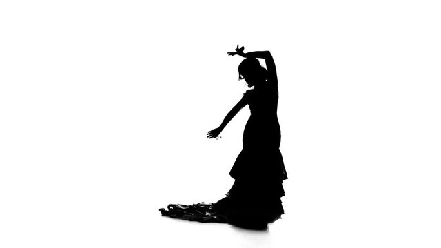 Flamenco. Girl is dancing castanets in her hands dancing. White background. Silhouette