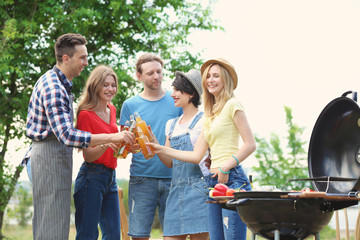Young people having barbecue with modern grill outdoors