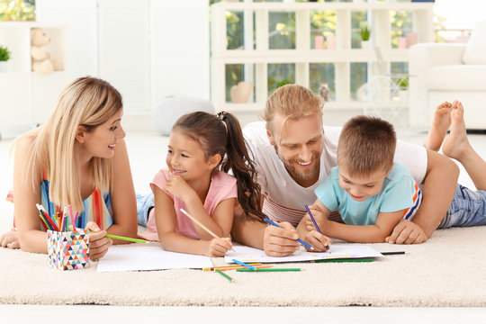 Cute children drawing with parents at home