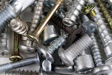 Screws on a white table. Accessories for screw connections.