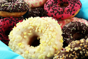 assorted donuts with chocolate frosted, pink glazed and sprinkles donuts.