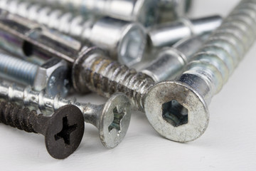 Screws on a white table. Accessories for screw connections.