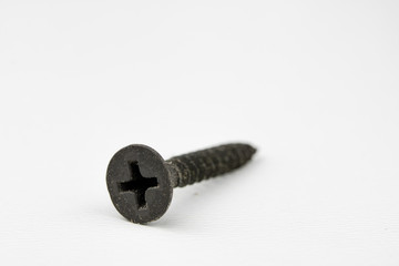 Screw head on a white table. Accessories for screw connections.