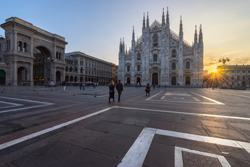 Fototapeta na wymiar Tourists couple walking into the Duomo cathedral at sunrise, Milan. Italy 