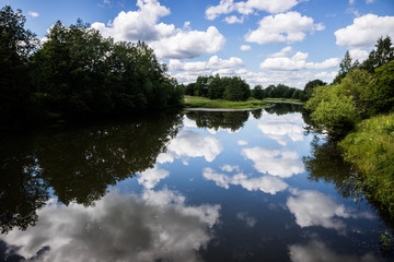 Fototapeta premium Calm lake water with clouds reflected. Sunny day.