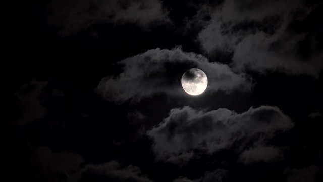 Full moon in a night cloudy sky.