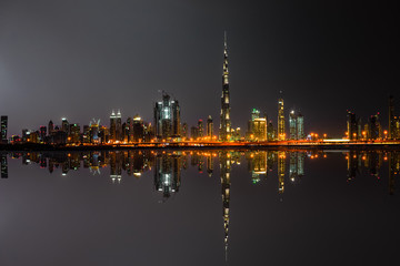 Night panorama of Dubai with reflection, UAE - warm colors 