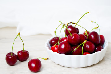 Cherries in white bowl. Cherry on white background. - healthy eating and food concept