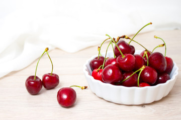Cherries in white bowl. Cherry on white background. - healthy eating and food concept