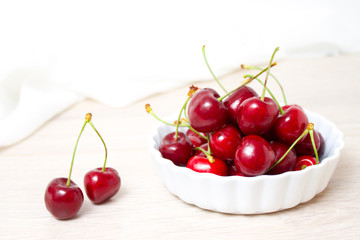 Cherries in white bowl. Cherry on white background. - healthy eating and food concept