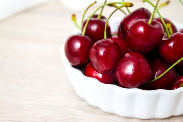Cherries in white bowl. Cherry on white background. - healthy eating and food concept