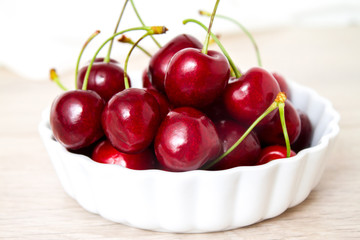 Cherries in white bowl. Cherry on white background. - healthy eating and food concept