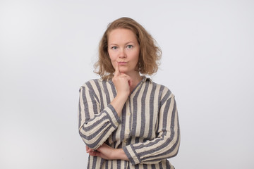 Middle aged european woman thinking and looking up, confused about an ide