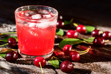 Fresh cherries and ice cherry fruit drink on wood