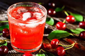 Fresh cherries and ice cherry fruit drink on wood