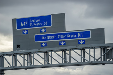 Close up view of M1 highway signs against cloudy sky in England 