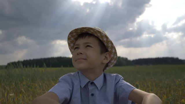 dreamer boy in the hat looks at the beautiful sky