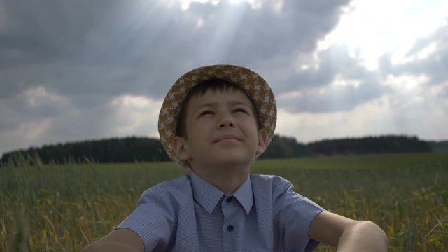 dreamer boy in the hat looks at the beautiful sky