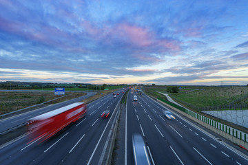 Fototapeta na wymiar Sunrise at M1 Motorway with cars in motion