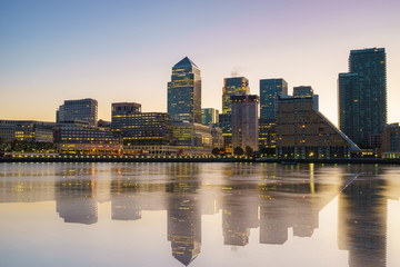 Fototapeta na wymiar Canary Wharf business district with water reflection at sunset