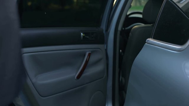 Driver opening car door to young respectable oligarch, professional chauffeur