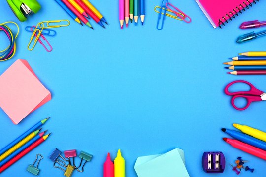 School supplies frame against a soft blue paper background