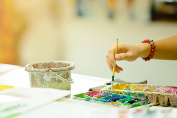Hand of artist with brush painting picture