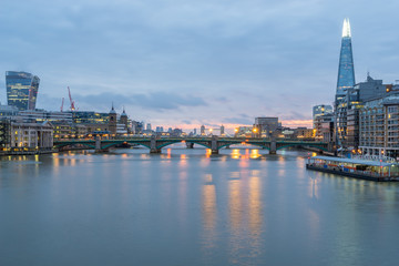 London skyline panorama including London Bridge and skyscrapers at financial district  at cloudy dawn