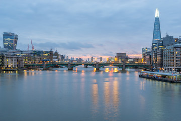 Fototapeta premium London skyline panorama including London Bridge and skyscrapers at financial district at cloudy dawn