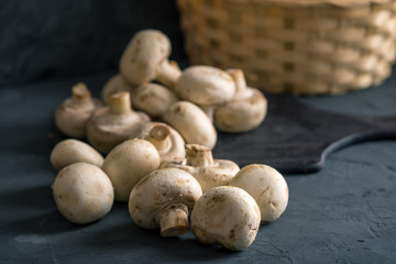 Champignons on the dark kitchen table. Cooking delicious dishes with mushrooms