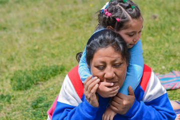 Tender portrait of indigenous South American woman with her little daughter in the countryside.