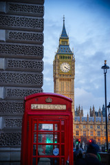 Big Ben, landmark of London at dusk with red telephone box in the foreground, selective focus