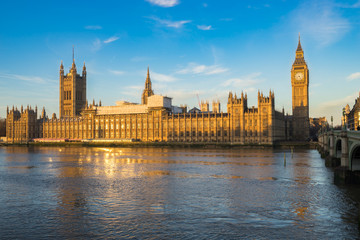 Fototapeta na wymiar Houses of Parliament and Big Ben with reflection in River Thames on an early morning shot in central London, UK