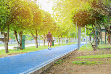 elderly people motion running feet in runner jogging exercise for health lose weight concept on track rubber cover blue public park. copy space add text, select focus with shallow depth of field.