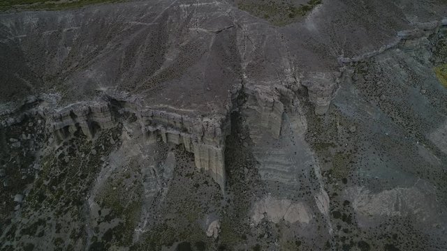 Rock formations with castle, houses silhuette. Castillos de Pincheira turistic place. Aerial to top view scene moving sideways gently. Patagonia, Malargüe