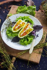 Green raw bell peppers stuffed with quinoa, bulgur, tomato, basil leaves and other vegetables with oil and rock salt for lunch or dinner. Vegan vegetarian healthy food.