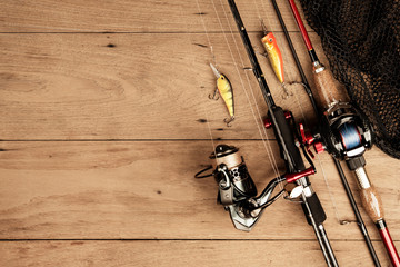 Fishing tackle on wood background on top view