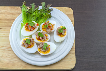 Close up salted egg salad , mix many vegetable ,Mix boiled egg ,Thai food in white dish on white block  wooden background.